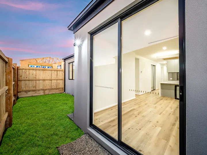 Rear sliding doors and yard at dusk, in the Aspen 25, built by Oakview at Oak Grove, Clyde North
