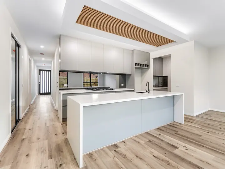 Kitchen island under a timber-batten bulkhead, in the Aspen 25, built by Oakview at Oak Grove, Clyde North