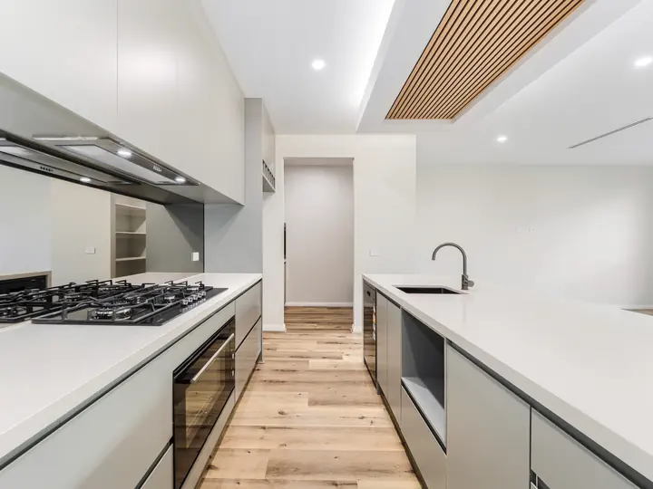 Galley kitchen with a gas cooktop and stone benchtops, in the Aspen 25, built by Oakview at Oak Grove, Clyde North