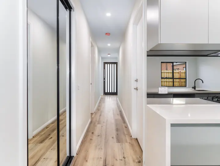 Long hallway with timber-look floors, in the Aspen 25, built by Oakview at Oak Grove, Clyde North