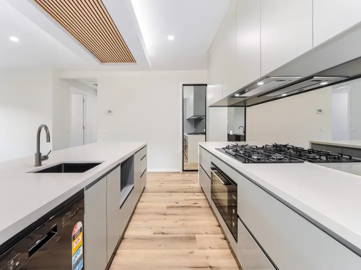 Kitchen sink and gooseneck mixer beside the cooktop, in the Aspen 25, built by Oakview at Oak Grove, Clyde North