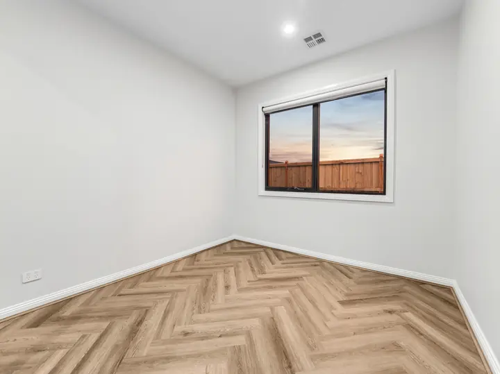 Bedroom with herringbone flooring, in a single-storey home Oakview built in Clyde North