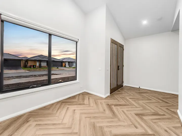 Bedroom with a black-framed window, in a single-storey home Oakview built in Clyde North