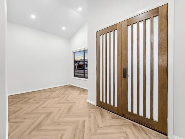 Double timber entry doors with glass slots, in a single-storey home Oakview built in Clyde North