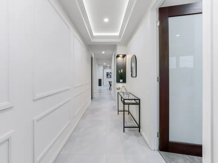 Hallway with a pivot entry door and a lit bulkhead, in a family home Oakview built in Clyde North