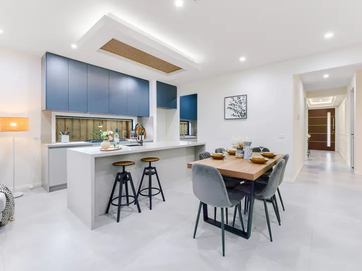 Kitchen island with a breakfast bar and stools, in a family home Oakview built in Clyde North