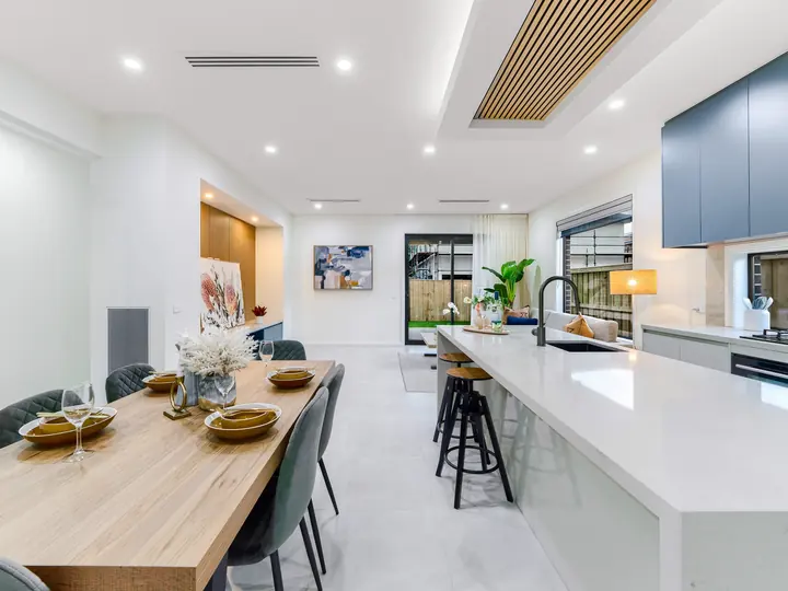 Dining table beside the kitchen island, in a family home Oakview built in Clyde North