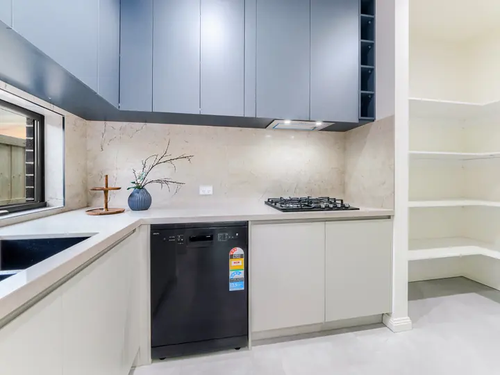 Kitchen with a window splashback and dark overhead cupboards, in a family home Oakview built in Clyde North