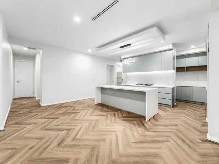 Kitchen island under a lit bulkhead, in a single-storey home Oakview built in Clyde North