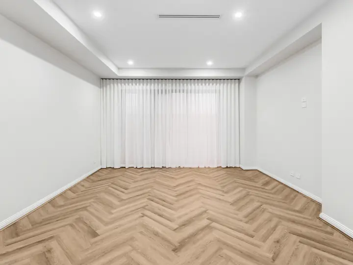 Living room with herringbone floors and sheer curtains, in a single-storey home Oakview built in Clyde North