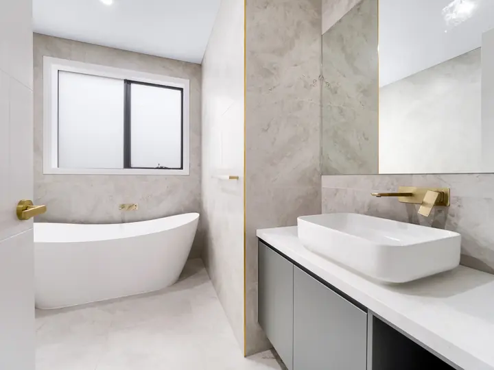 Freestanding bath and vanity with gold tapware, in a custom home Oakview finished in brushed gold fittings