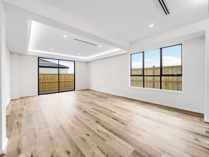 Family room with a lit bulkhead, in a custom home Oakview finished in brushed gold fittings