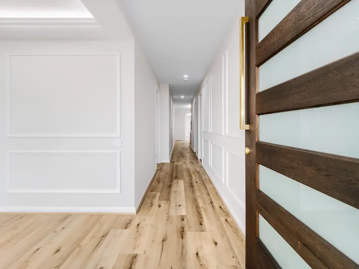 Hallway with panelled walls, in a custom home Oakview finished in brushed gold fittings
