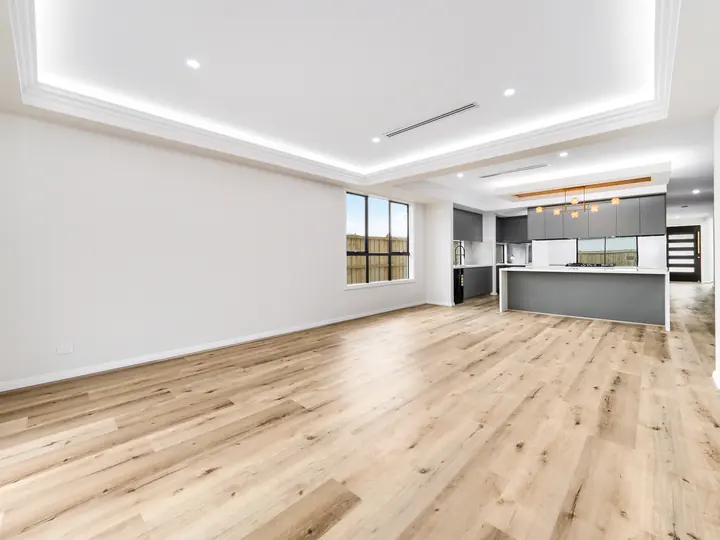 Open-plan living looking through to the kitchen, in a custom home Oakview finished in brushed gold fittings