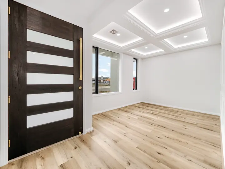 Black pivot entry door with glass panels, in a custom home Oakview finished in brushed gold fittings