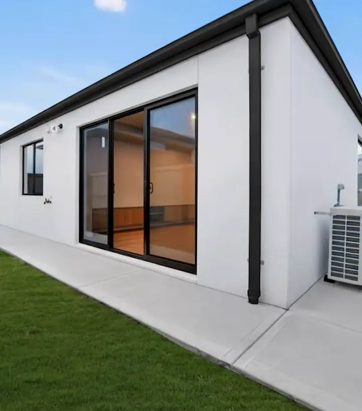 Rear of the home with sliding doors and lawn, in the Sienna 23 by Oakview Homes